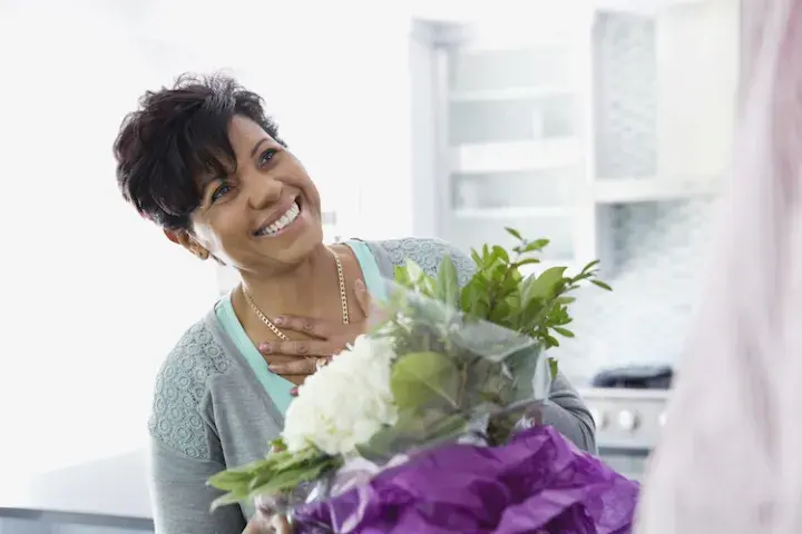 FTD companies, woman smiling with flowers