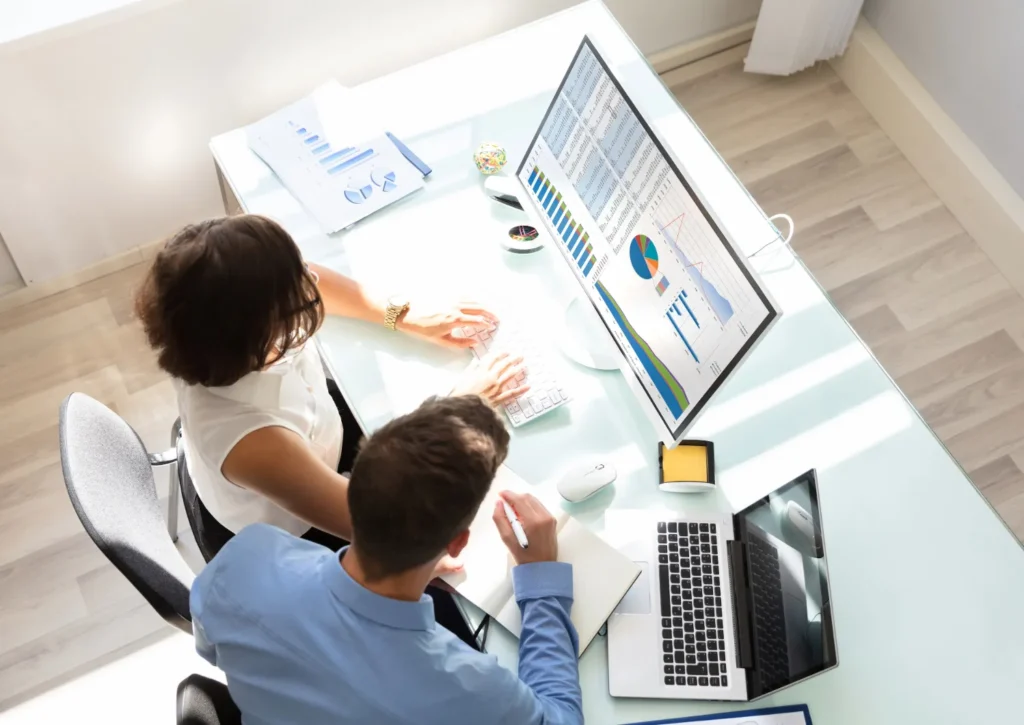 Financial professionals at desk with computers.
